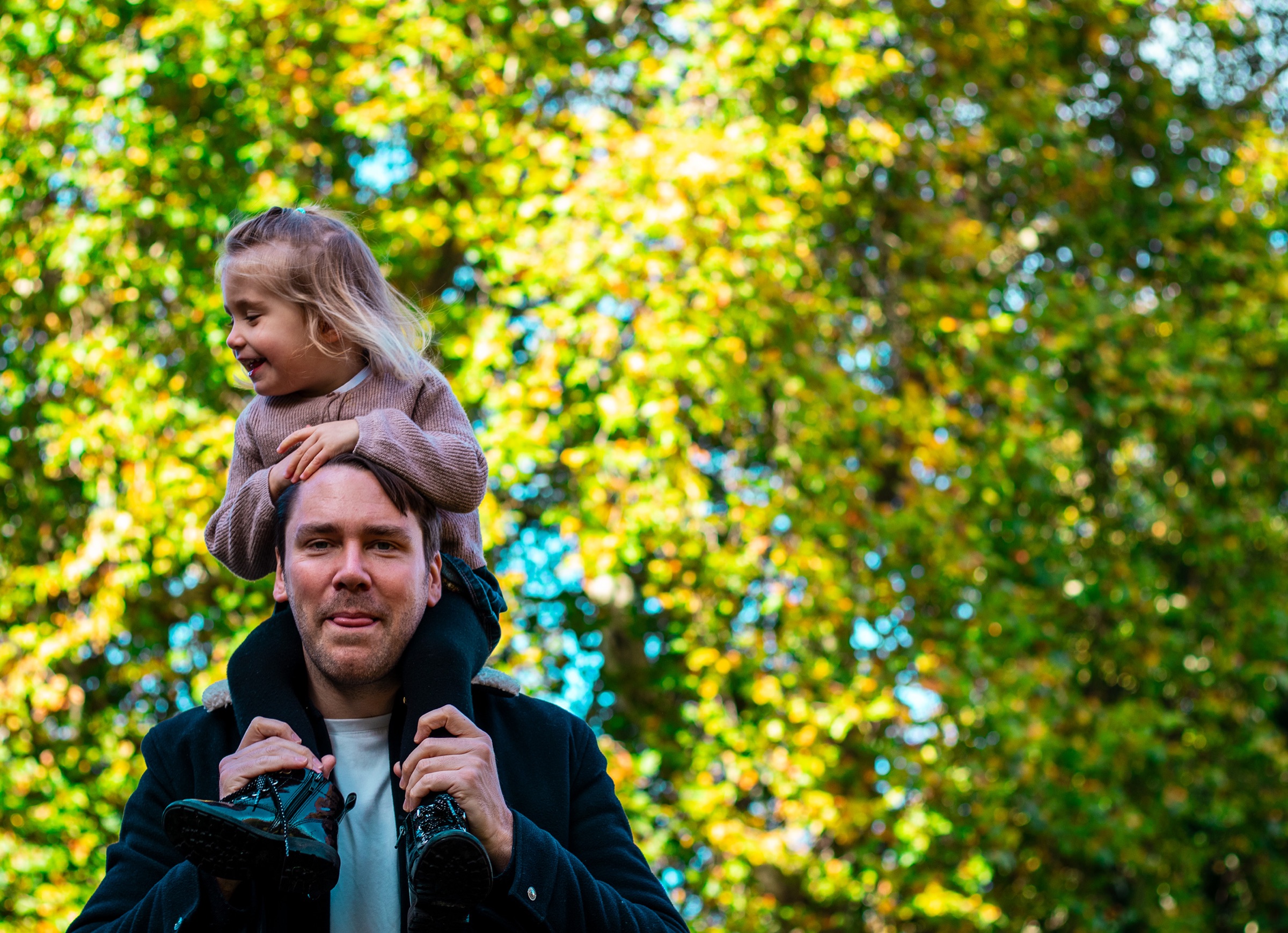 Daughter sitting on dad's shoulders — family portrait